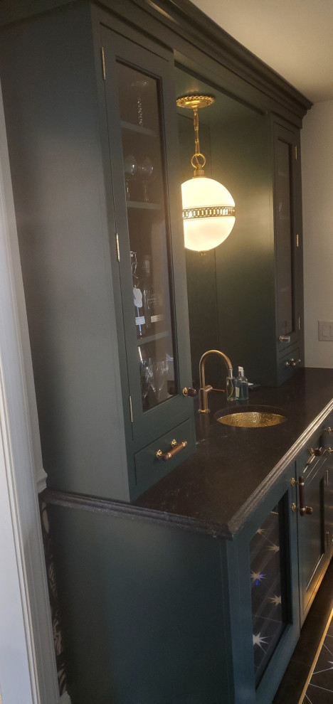 This is an example of a mid-sized transitional galley wet bar in New York with an undermount sink, recessed-panel cabinets, green cabinets, mirror splashback, marble floors and black floor.