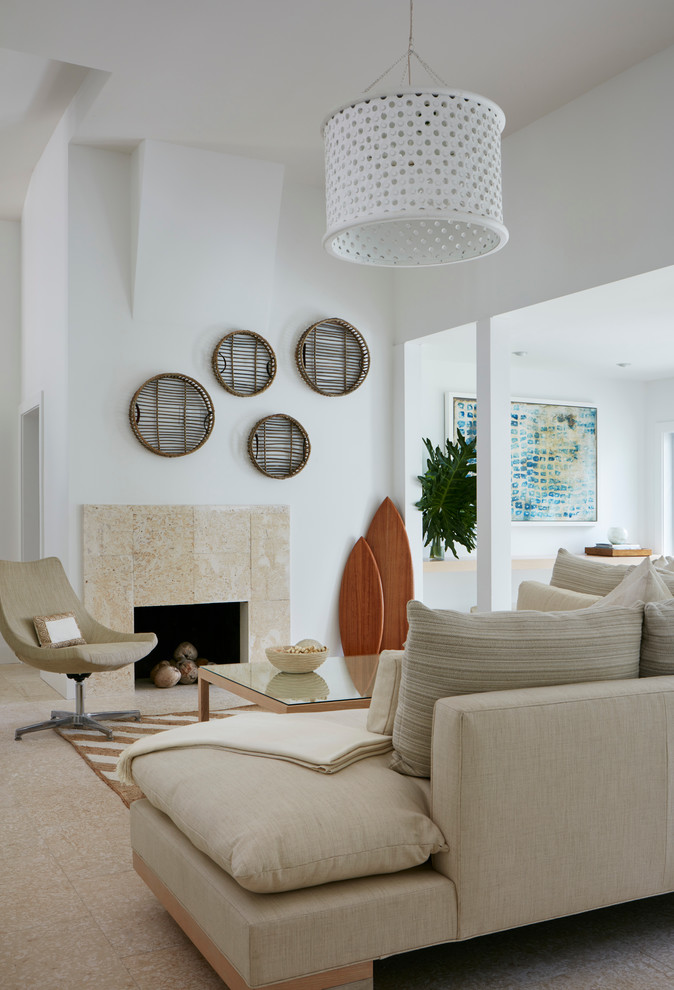 This is an example of a beach style living room in Miami with white walls, a standard fireplace and a tile fireplace surround.