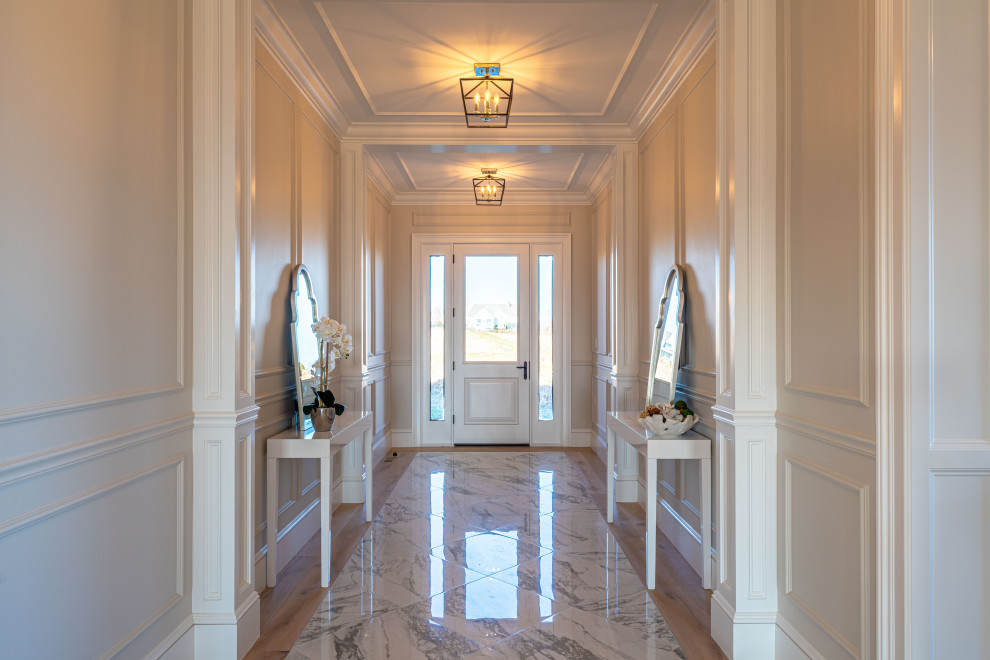 Expansive classic foyer in Providence with white walls, marble flooring, a single front door, a glass front door, white floors, a drop ceiling and wood walls.