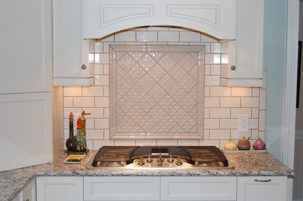 Inspiration for a transitional u-shaped eat-in kitchen remodel in Raleigh with an undermount sink, recessed-panel cabinets, white cabinets, quartzite countertops, white backsplash, subway tile backsplash and stainless steel appliances