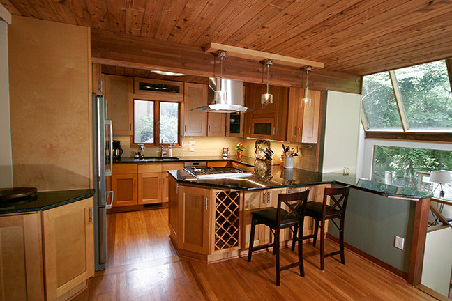 Eat-in kitchen - small transitional l-shaped porcelain tile eat-in kitchen idea with shaker cabinets, light wood cabinets, granite countertops, beige backsplash, glass tile backsplash, stainless steel appliances and a peninsula