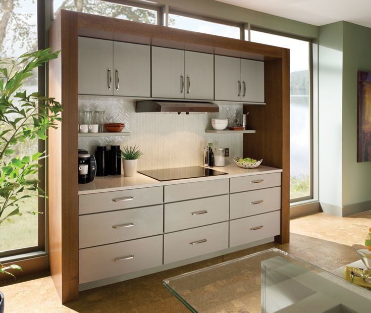 This is an example of a mid-sized modern galley separate kitchen in New Orleans with an undermount sink, flat-panel cabinets, medium wood cabinets, laminate benchtops, white splashback, ceramic splashback, stainless steel appliances, cork floors and with island.