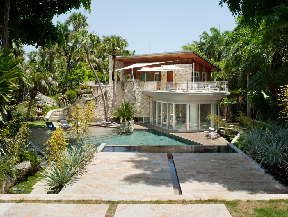 This is an example of a small beach style two-storey glass white exterior in Miami.
