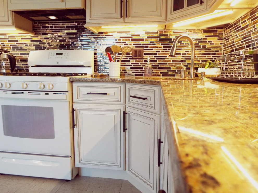 Design ideas for a small traditional l-shaped separate kitchen in New York with an undermount sink, raised-panel cabinets, beige cabinets, granite benchtops, brown splashback, mosaic tile splashback, white appliances, no island and orange benchtop.
