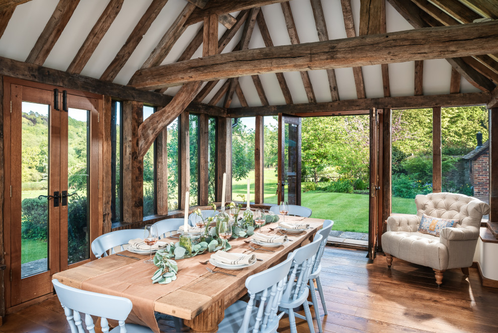 This is an example of a large farmhouse enclosed dining room in Surrey with medium hardwood flooring.