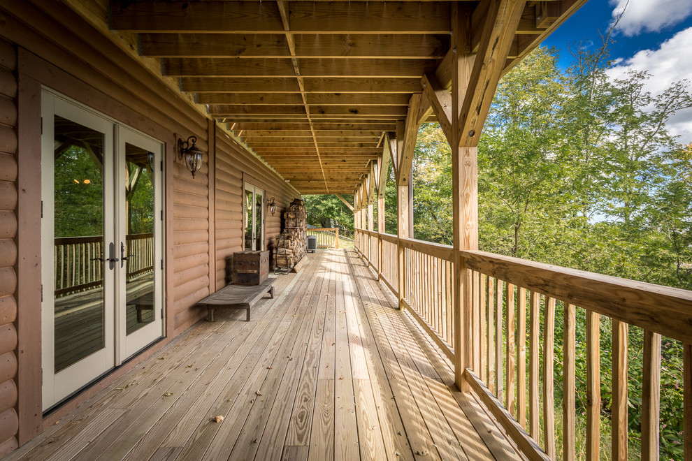 Inspiration for a huge rustic backyard deck remodel in Charlotte with a roof extension