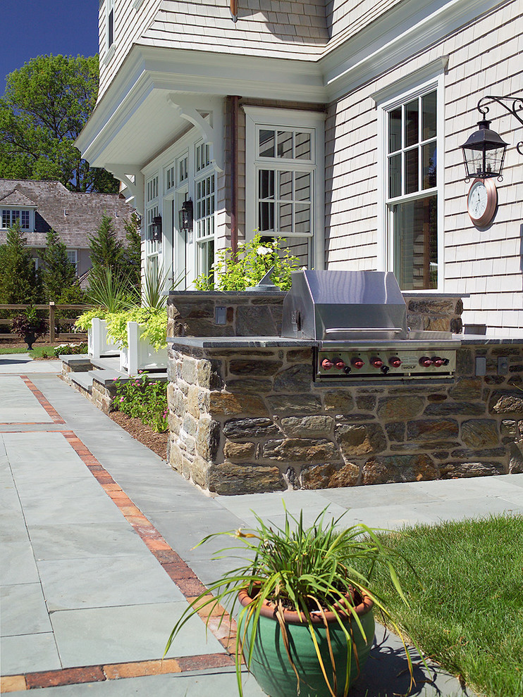 Traditional patio in Philadelphia with an outdoor kitchen and natural stone pavers.