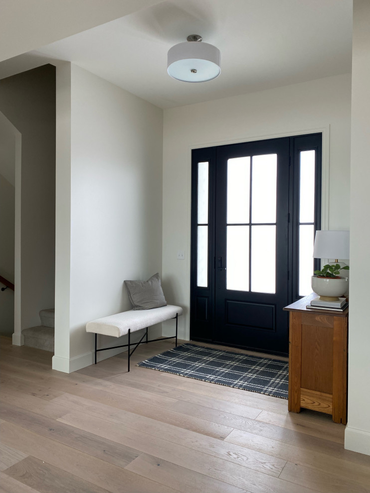 Design ideas for a mid-sized modern front door in Omaha with white walls, light hardwood floors, a single front door, a black front door, multi-coloured floor, exposed beam and planked wall panelling.