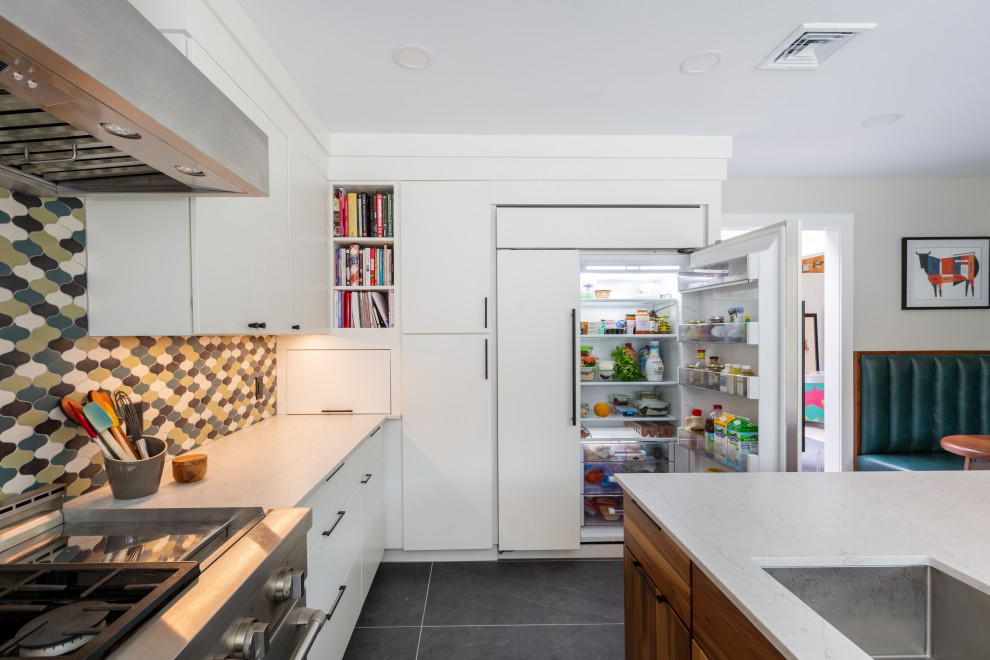 This is an example of a large midcentury kitchen pantry in New York with a submerged sink, flat-panel cabinets, white cabinets, engineered stone countertops, ceramic splashback, integrated appliances, porcelain flooring, an island, grey floors and white worktops.