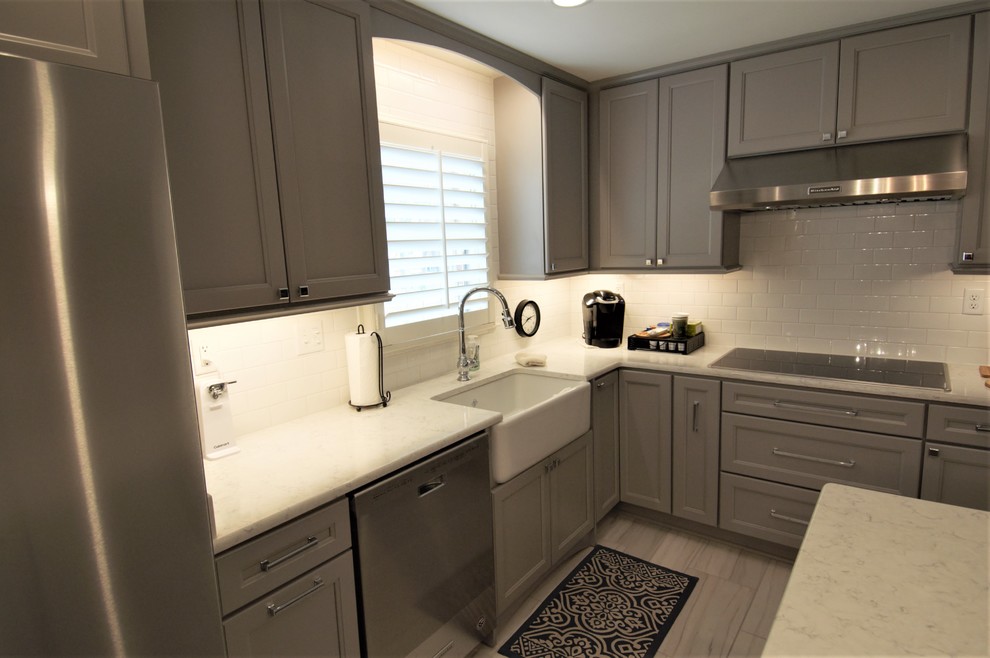 Eat-in kitchen - large transitional u-shaped porcelain tile and beige floor eat-in kitchen idea with a farmhouse sink, recessed-panel cabinets, gray cabinets, granite countertops, white backsplash, subway tile backsplash, stainless steel appliances, an island and beige countertops