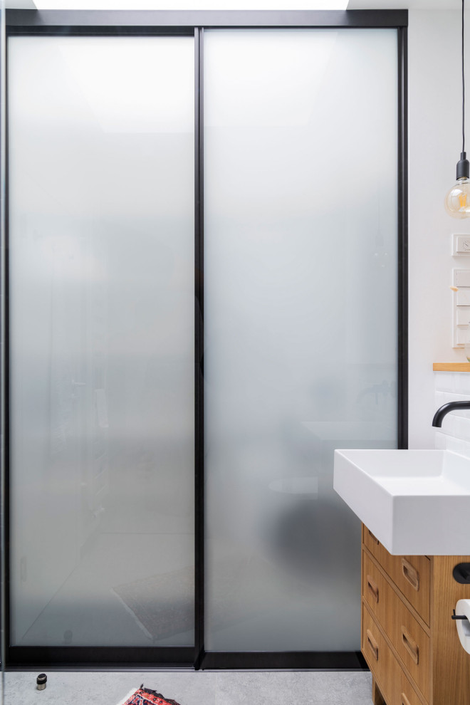 Modelo de cuarto de baño a medida moderno con paredes blancas, suelo de madera clara y suelo beige