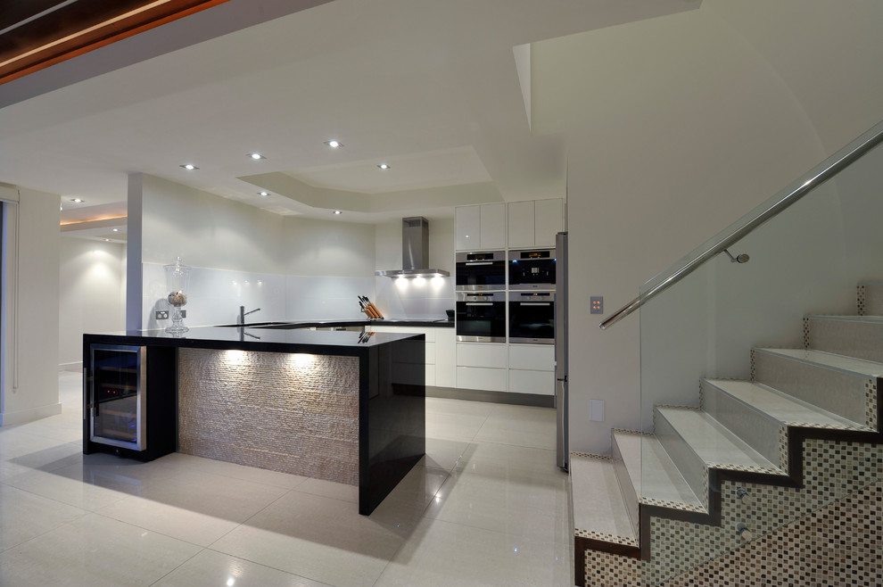 Design ideas for a mid-sized transitional u-shaped eat-in kitchen in Brisbane with an undermount sink, flat-panel cabinets, white cabinets, marble benchtops, white splashback, porcelain splashback, stainless steel appliances and porcelain floors.