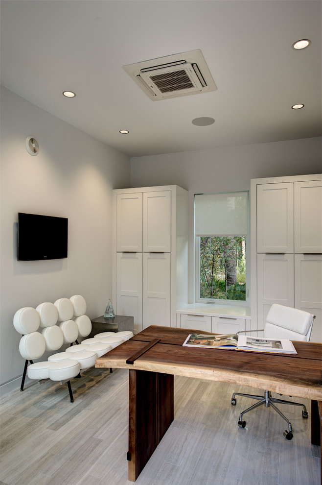 This is an example of a contemporary home office in Orlando with white walls and beige floor.