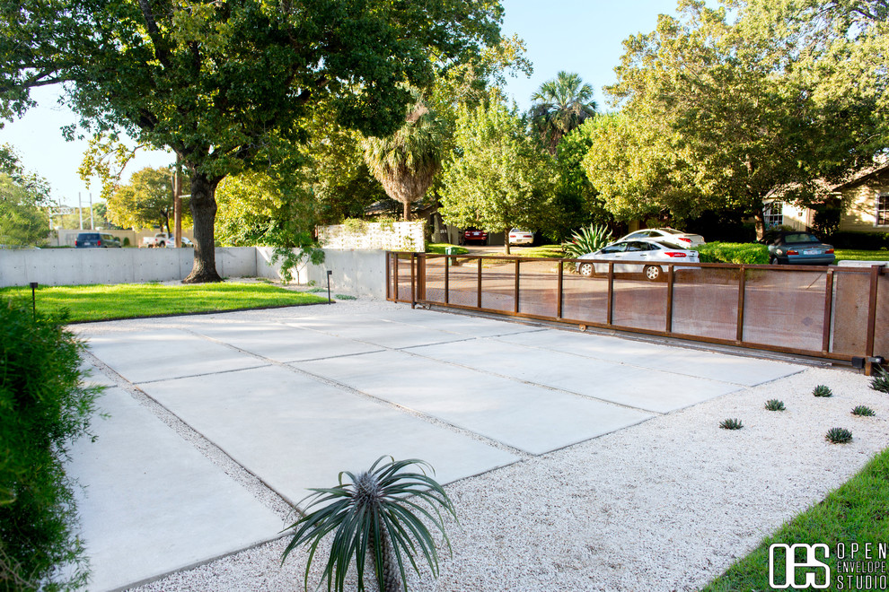 Photo of a mid-sized modern front yard full sun xeriscape in Austin with concrete pavers.