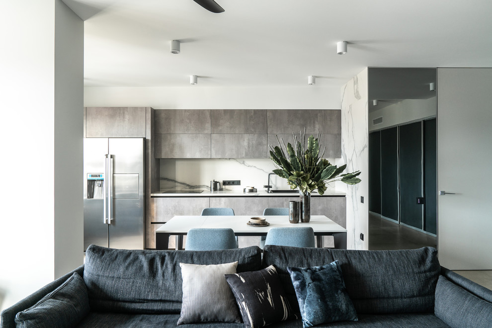 Design ideas for a contemporary single-wall open plan kitchen in Other with a drop-in sink, flat-panel cabinets, grey cabinets, white splashback, white benchtop, stone slab splashback, stainless steel appliances, no island, porcelain floors and grey floor.