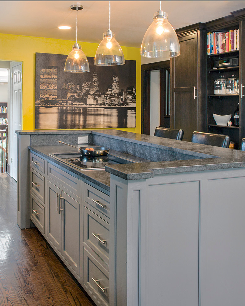 Eat-in kitchen - mid-sized transitional galley medium tone wood floor eat-in kitchen idea with a farmhouse sink, beaded inset cabinets, dark wood cabinets, granite countertops, beige backsplash, ceramic backsplash, stainless steel appliances, multicolored walls and an island