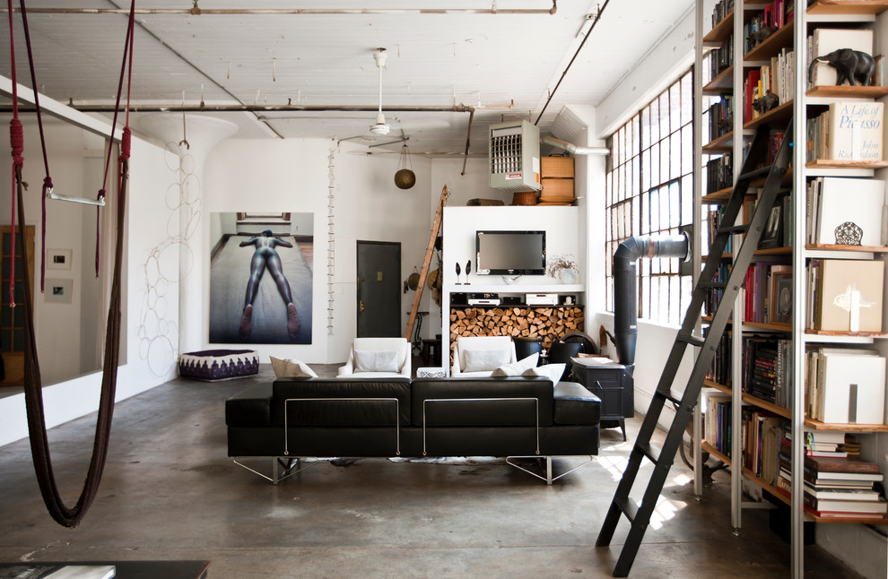 Photo of an industrial living room in New York with concrete floors.