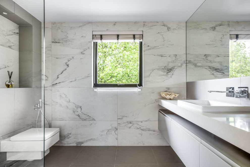 Inspiration for a large contemporary 3/4 bathroom in London with flat-panel cabinets, grey cabinets, an open shower, a wall-mount toilet, white tile, porcelain tile, porcelain floors, an integrated sink, engineered quartz benchtops, grey floor and an open shower.