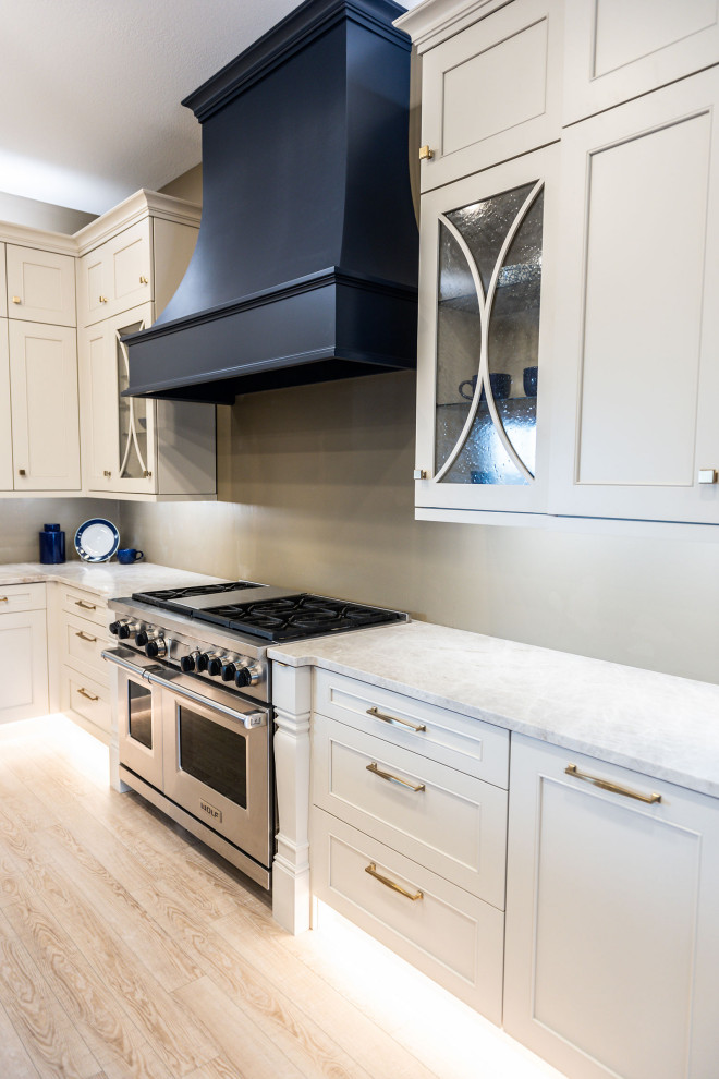 Mid-sized traditional l-shaped kitchen pantry in Other with a single-bowl sink, recessed-panel cabinets, white cabinets, quartzite benchtops, white splashback, ceramic splashback, stainless steel appliances, vinyl floors, with island, beige floor and white benchtop.