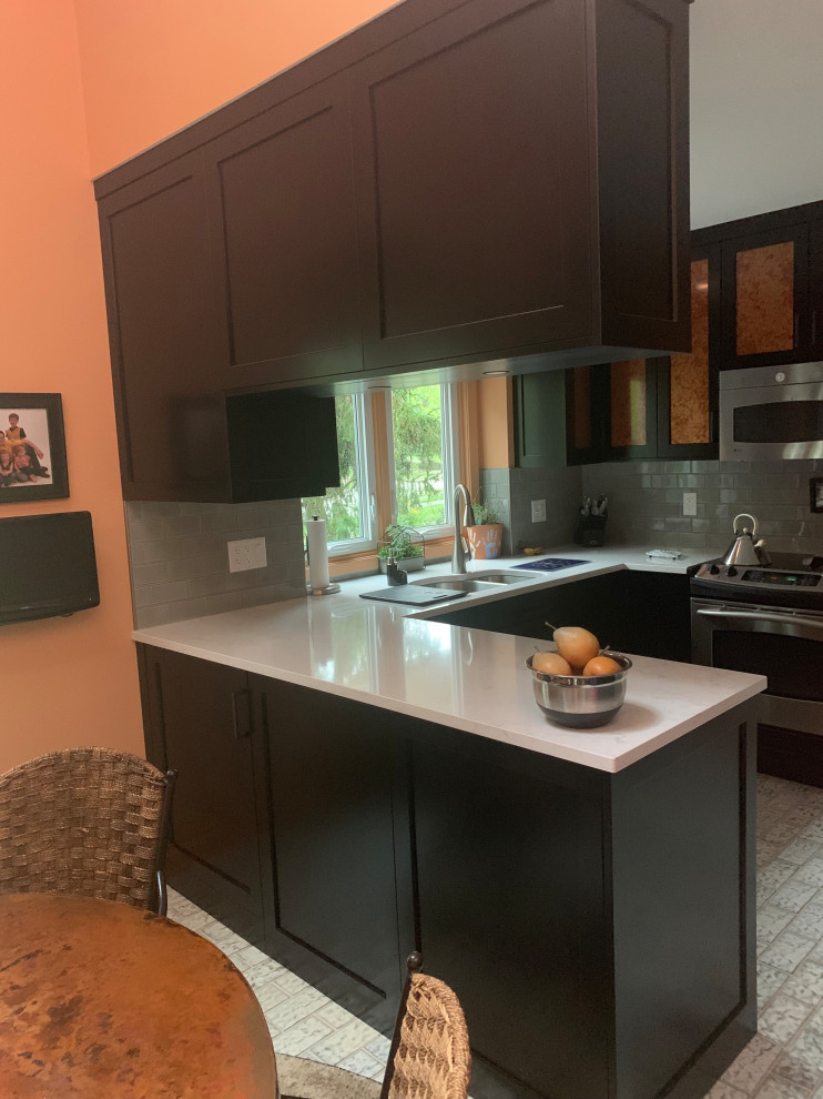 Enclosed kitchen - small transitional u-shaped ceramic tile and multicolored floor enclosed kitchen idea in Indianapolis with a double-bowl sink, recessed-panel cabinets, black cabinets, quartz countertops, gray backsplash, ceramic backsplash, stainless steel appliances, a peninsula and gray countertops