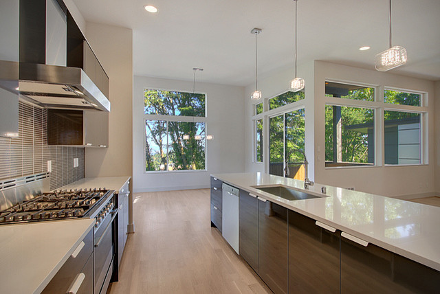 Photo of a mid-sized contemporary galley open plan kitchen in Seattle with flat-panel cabinets and medium wood cabinets.