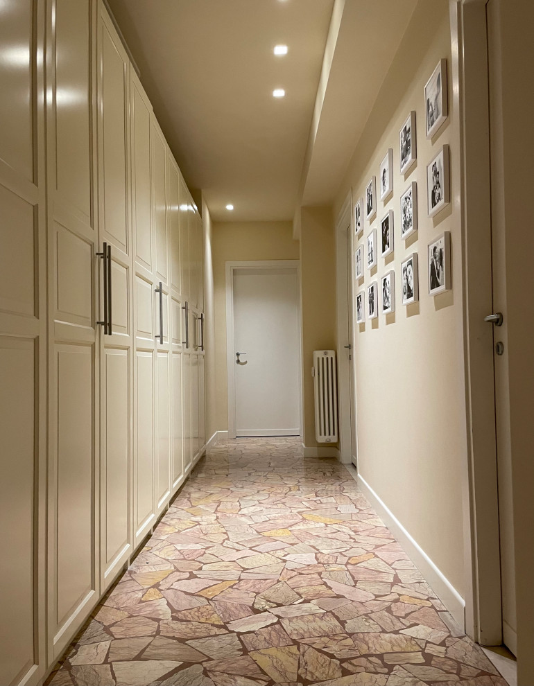 Exemple d'un grand couloir tendance avec un mur beige, un sol en terrazzo et un sol beige.