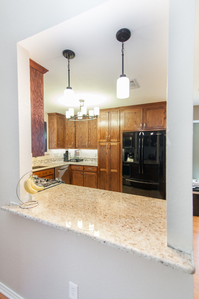 This is an example of a mid-sized traditional galley eat-in kitchen in Dallas with an undermount sink, medium wood cabinets, granite benchtops, beige splashback, ceramic splashback, stainless steel appliances and a peninsula.
