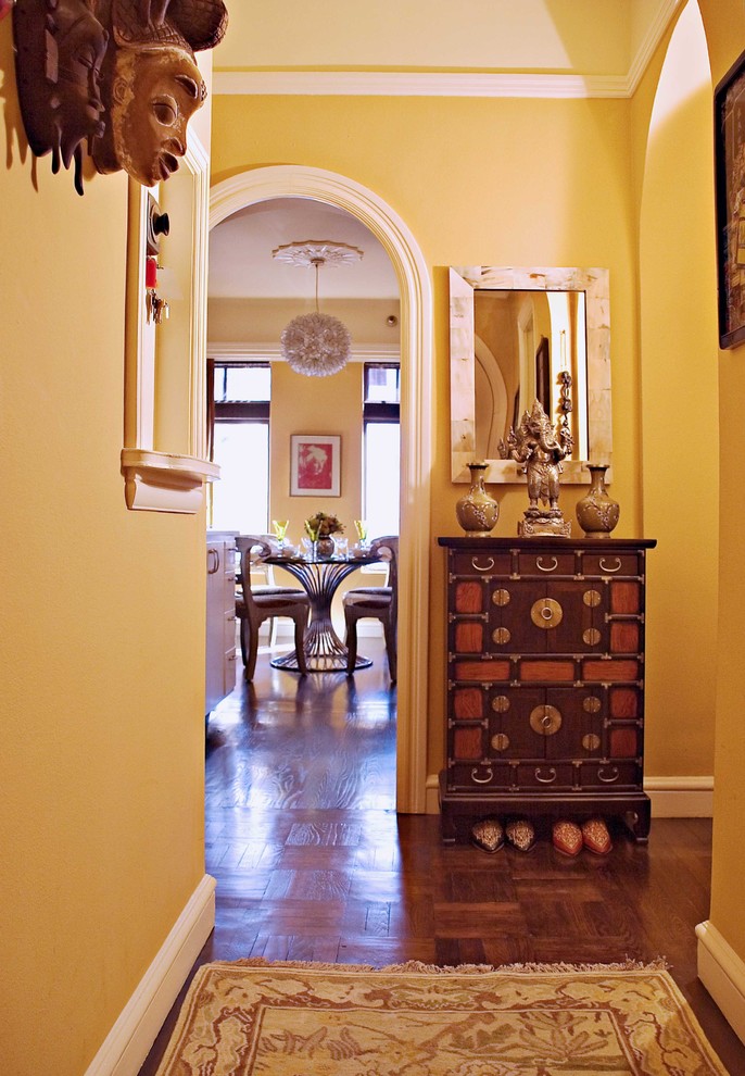 Design ideas for an eclectic entry hall in San Francisco with yellow walls and dark hardwood floors.