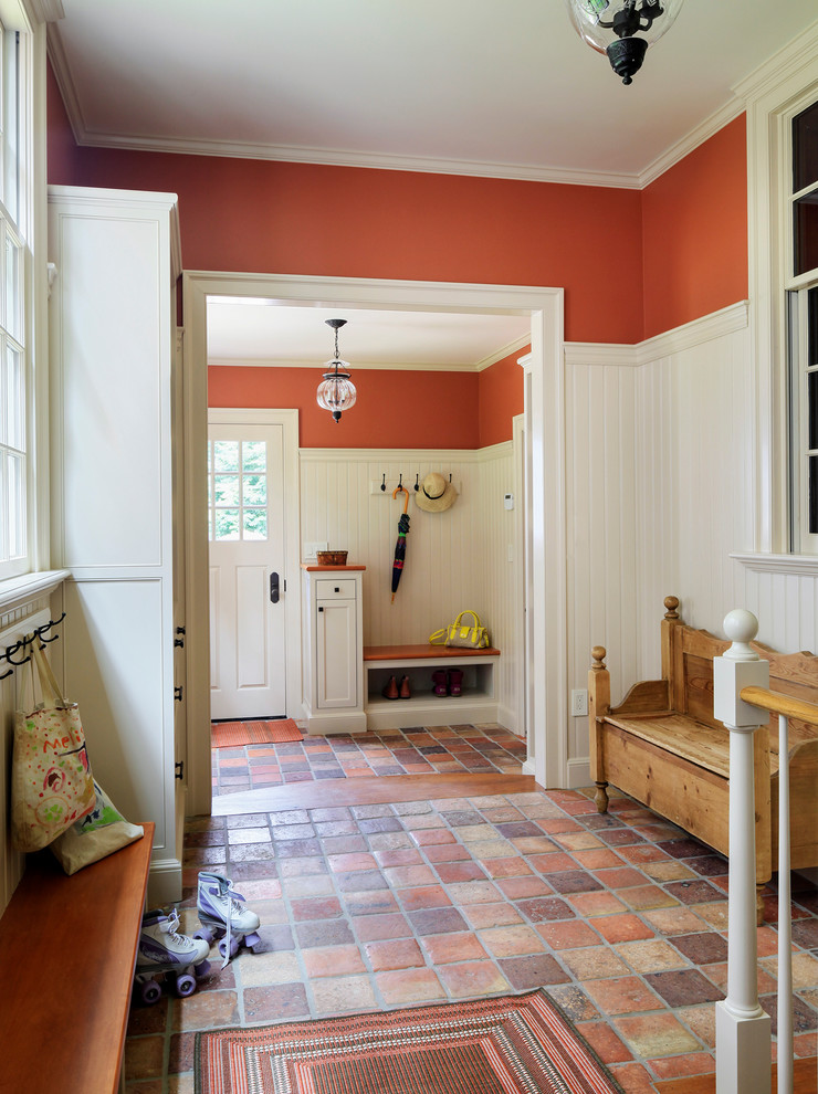 Photo of a traditional hallway in Boston with orange walls, terra-cotta floors and orange floor.