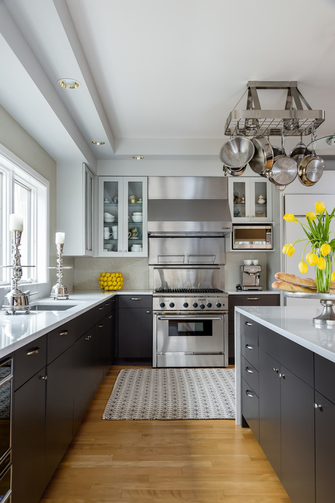 Kitchen - large transitional l-shaped light wood floor kitchen idea with flat-panel cabinets, dark wood cabinets, gray backsplash, stainless steel appliances and an island