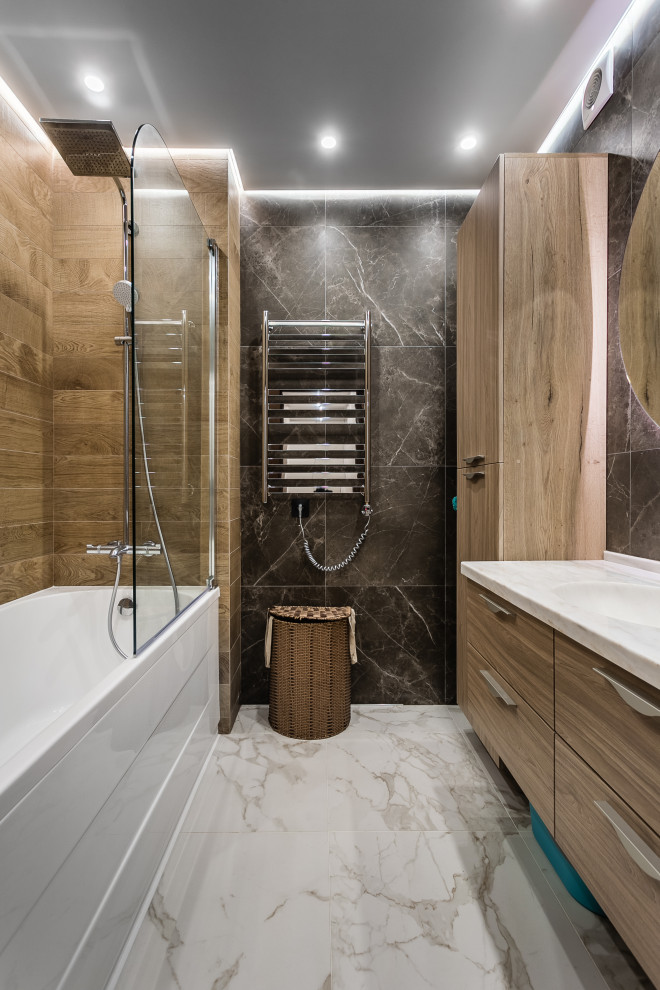 Photo of a large contemporary master bathroom in Moscow with flat-panel cabinets, light wood cabinets, an alcove tub, a shower/bathtub combo, black tile, porcelain tile, porcelain floors, an integrated sink, grey floor, white benchtops and a floating vanity.