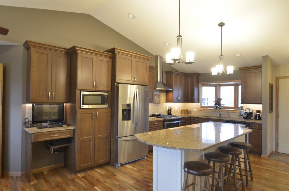 Example of a mid-sized transitional l-shaped medium tone wood floor open concept kitchen design in Minneapolis with a single-bowl sink, flat-panel cabinets, brown cabinets, granite countertops, beige backsplash, glass tile backsplash, stainless steel appliances and an island
