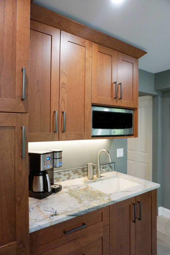 Example of a mid-sized transitional porcelain tile and gray floor eat-in kitchen design with recessed-panel cabinets, medium tone wood cabinets, quartzite countertops, green backsplash, mosaic tile backsplash, stainless steel appliances and an island