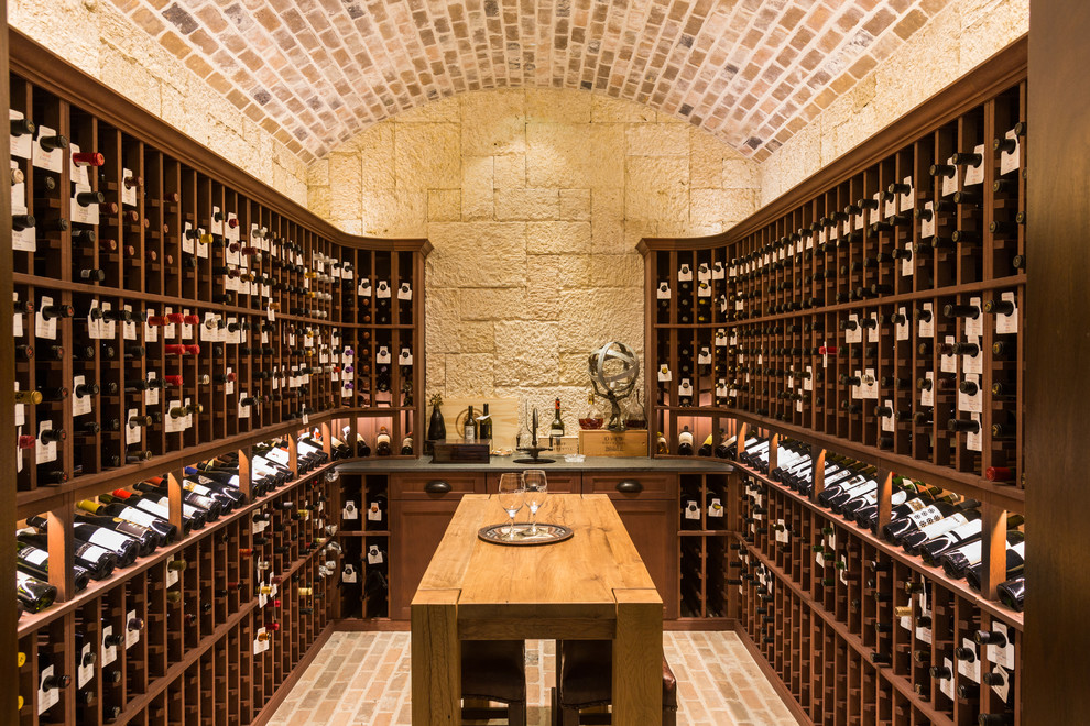 Inspiration for a traditional wine cellar in Houston with storage racks and brick floors.