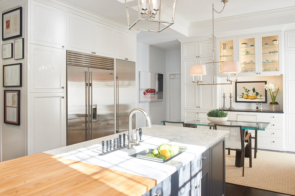 Large transitional dark wood floor eat-in kitchen photo in Los Angeles with an undermount sink, recessed-panel cabinets, white cabinets, granite countertops, white backsplash, stone tile backsplash, stainless steel appliances and an island