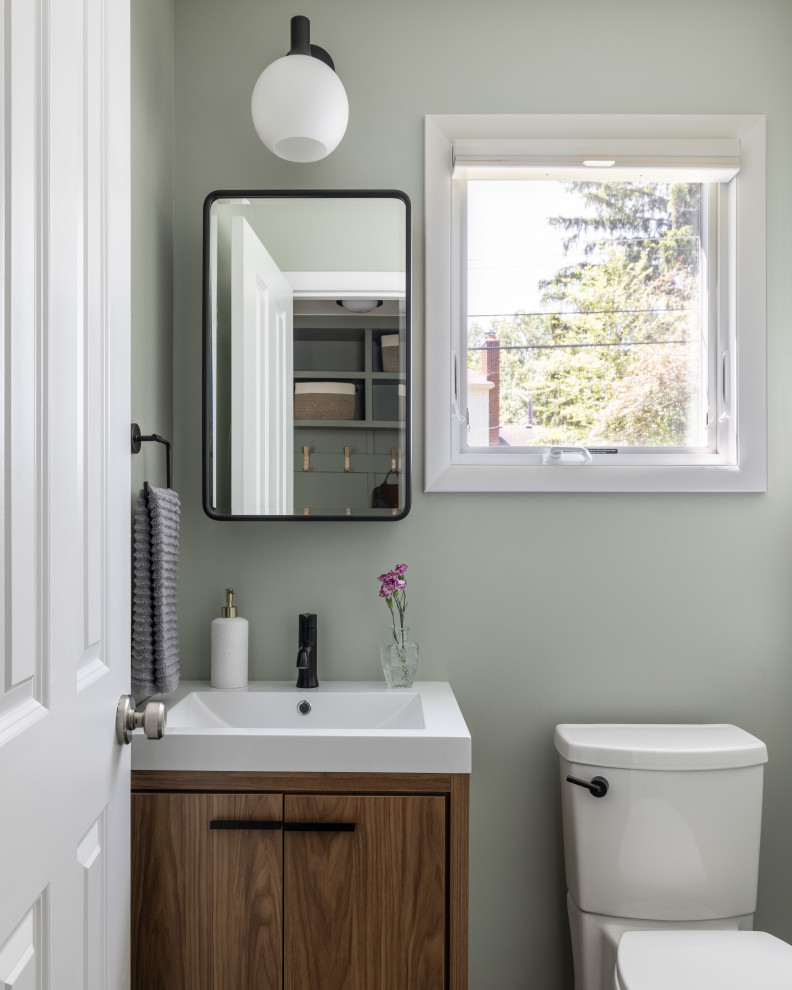 Inspiration for a small transitional powder room remodel in Detroit with dark wood cabinets, green walls and white countertops