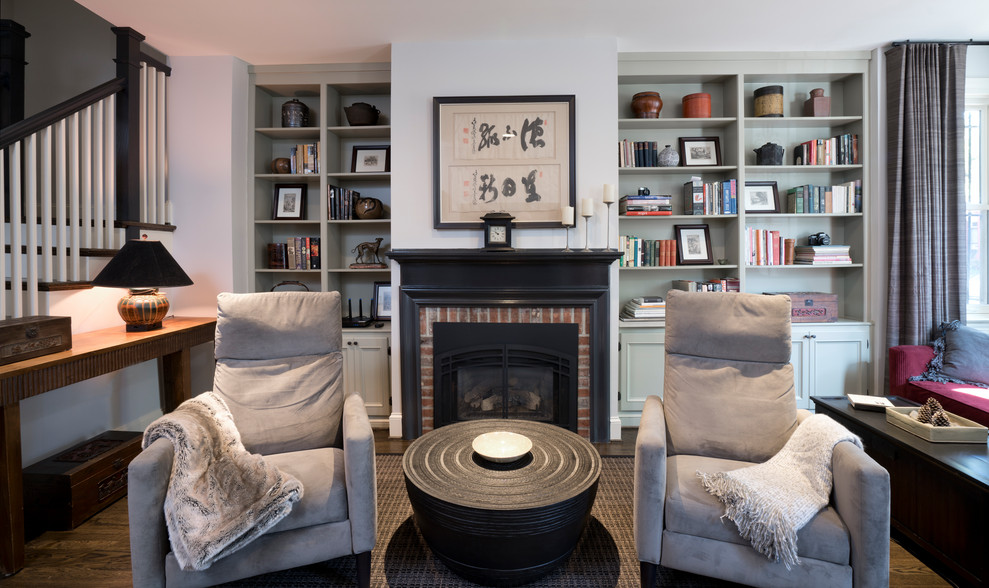 Mid-sized contemporary open concept living room in DC Metro with a library, grey walls, dark hardwood floors, a standard fireplace, a wood fireplace surround, a freestanding tv and brown floor.