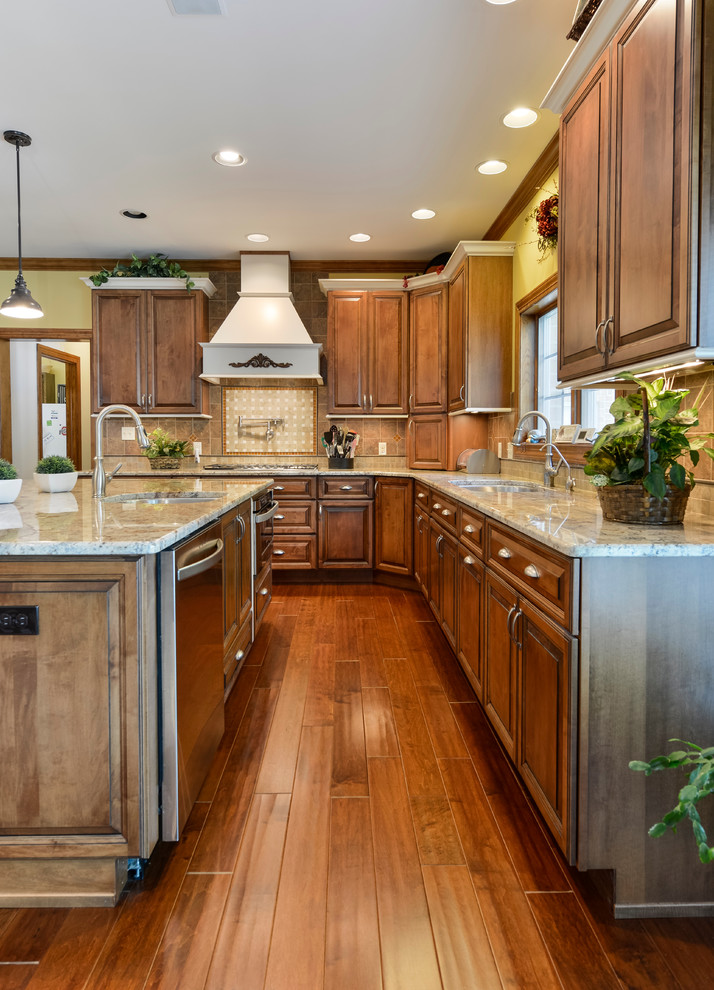 Inspiration for a large transitional u-shaped medium tone wood floor and brown floor eat-in kitchen remodel with beaded inset cabinets, medium tone wood cabinets, granite countertops, beige backsplash, mosaic tile backsplash, stainless steel appliances, an island and an undermount sink