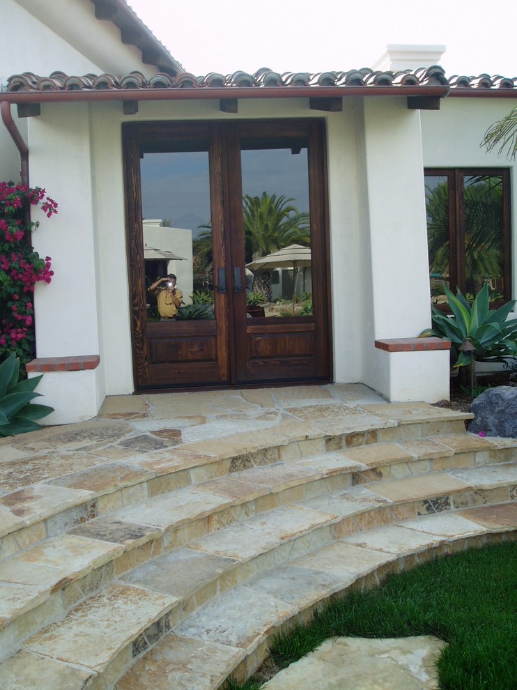 Mid-sized mediterranean backyard partial sun garden in San Diego with a fire feature and natural stone pavers for summer.
