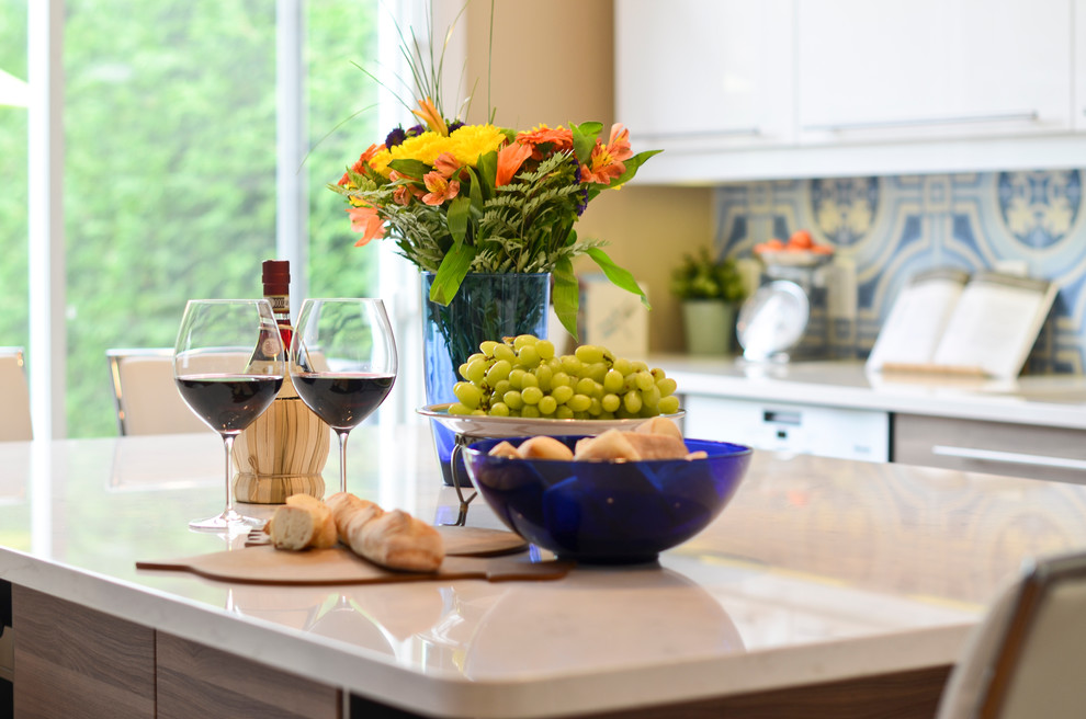 Mid-sized minimalist l-shaped cork floor eat-in kitchen photo in Ottawa with an undermount sink, flat-panel cabinets, white cabinets, quartzite countertops, blue backsplash, porcelain backsplash, stainless steel appliances and an island