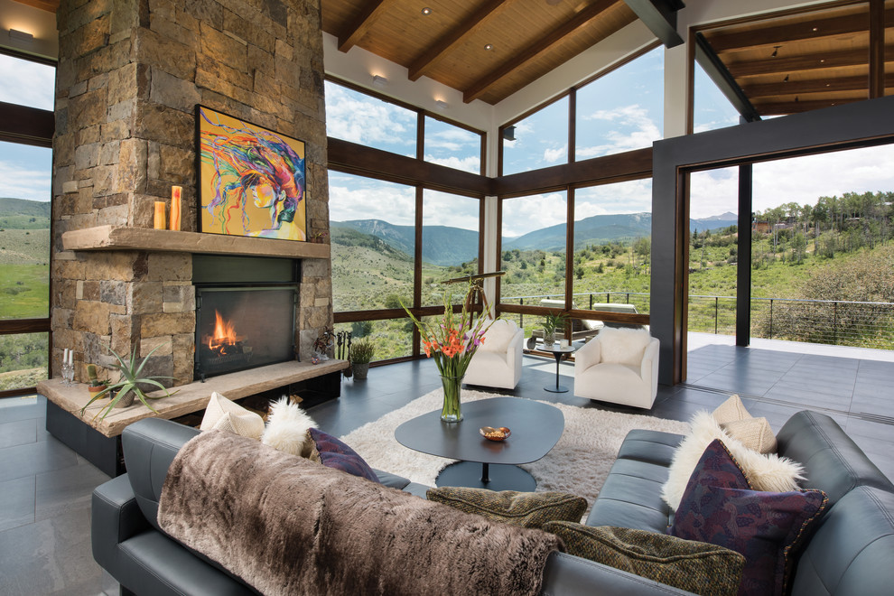 This is an example of an expansive contemporary open concept living room in Denver with white walls, porcelain floors, a standard fireplace, a stone fireplace surround and grey floor.