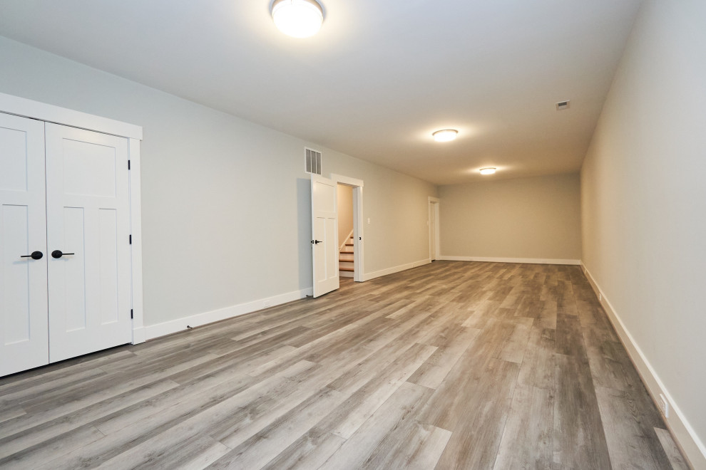 Inspiration for a large transitional walk-out vinyl floor and gray floor basement remodel in DC Metro with gray walls
