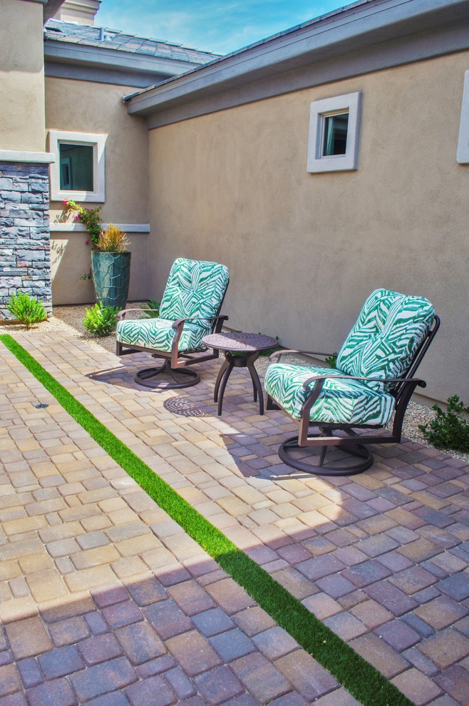 Mid-sized traditional backyard patio in Phoenix with brick pavers and a roof extension.