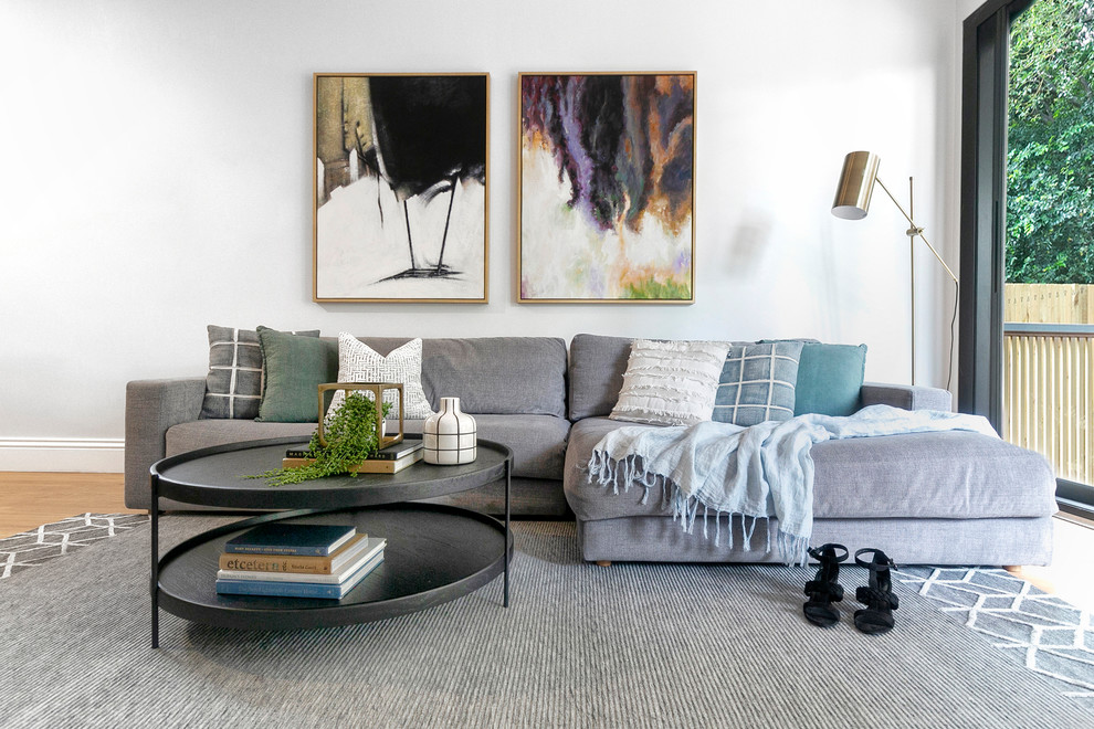 Contemporary living room in Sydney with white walls, medium hardwood floors and brown floor.