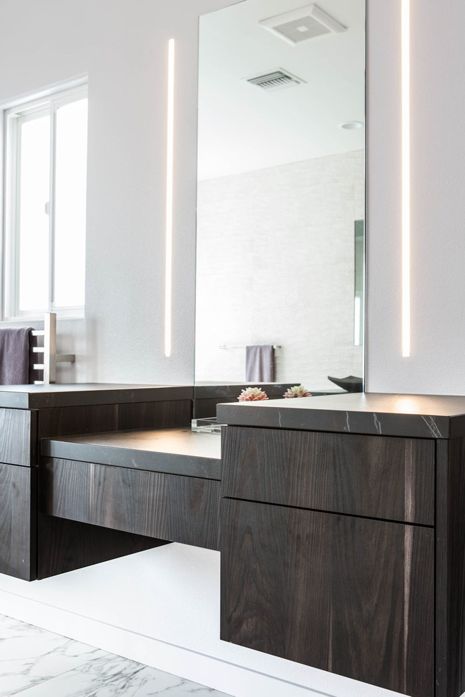 Mid-sized modern master bathroom in Los Angeles with flat-panel cabinets, dark wood cabinets, a drop-in tub, a corner shower, white walls, marble floors, a vessel sink, engineered quartz benchtops, white floor, a hinged shower door and black benchtops.