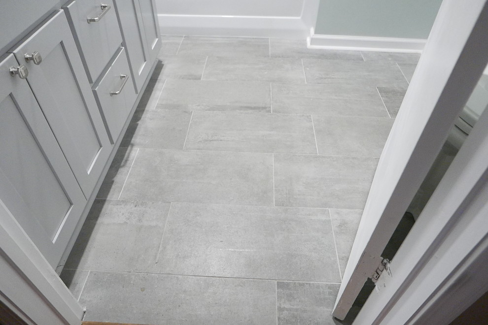 Alcove bathtub - mid-sized transitional kids' white tile and porcelain tile porcelain tile and gray floor alcove bathtub idea with shaker cabinets, gray cabinets, a two-piece toilet, green walls, an undermount sink, quartz countertops and white countertops