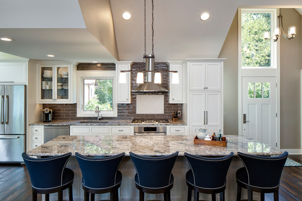 Inspiration for a large traditional kitchen in Minneapolis with an undermount sink, recessed-panel cabinets, white cabinets, granite benchtops, grey splashback, stainless steel appliances, dark hardwood floors, with island and subway tile splashback.