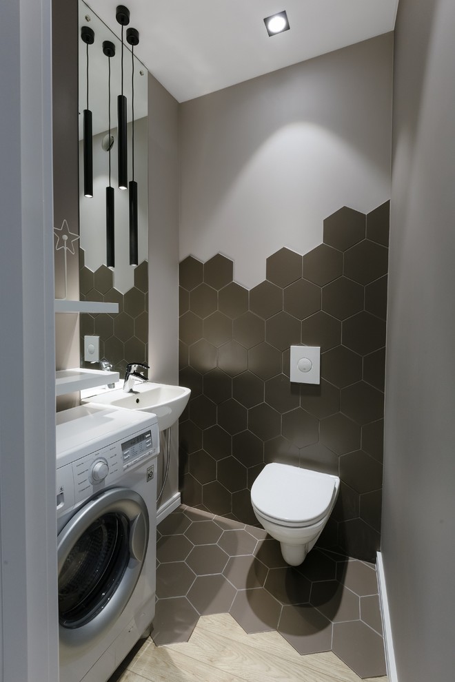 Inspiration for a large contemporary powder room in Other with a wall-mount toilet, gray tile, ceramic tile, grey walls, porcelain floors, a wall-mount sink and grey floor.
