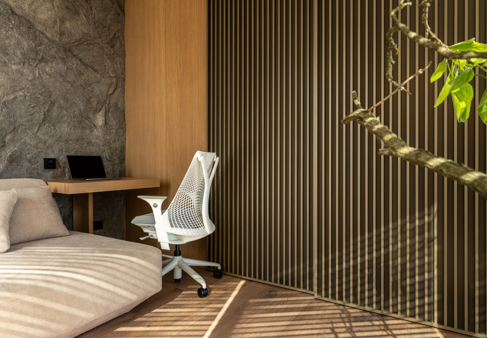 На фото: кабинет в скандинавском стиле с серыми стенами, светлым паркетным полом, угловым камином, коричневым полом и деревянными стенами
