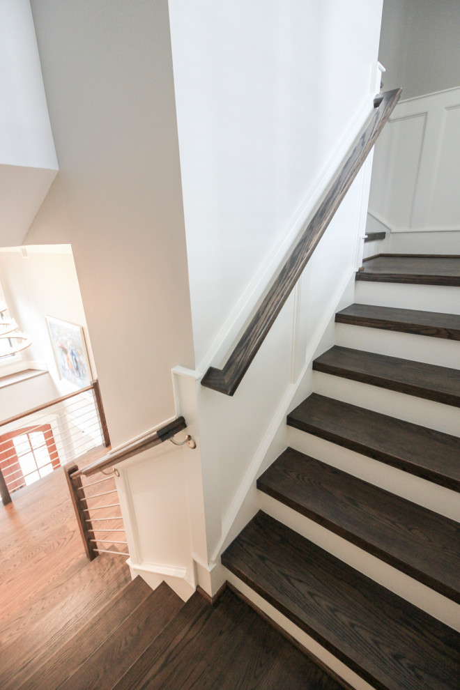 This is an example of a large contemporary wood u-shaped staircase in DC Metro with wood risers and mixed railing.